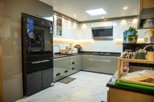 a kitchen with a black refrigerator and a tile floor at Zen space in Pātan