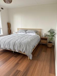 a bedroom with a bed and a wooden floor at Serenity House in Mallacoota