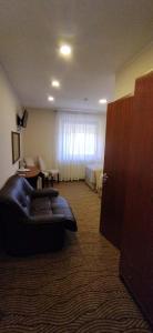 ein Wohnzimmer mit Ledersofa in einem Hotelzimmer in der Unterkunft Gilija in Šilutė