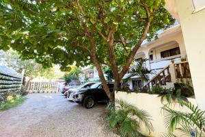 Ein Auto, das neben einem Baum in einer Einfahrt geparkt ist in der Unterkunft Stardust Beach Hotel Matabungkay Batangas in Lian