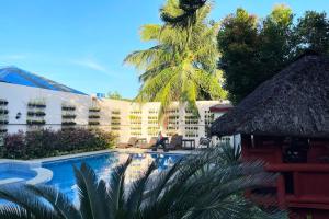 ein Resort mit Swimmingpool und Palme in der Unterkunft Stardust Beach Hotel Matabungkay Batangas in Lian
