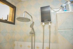 a shower in a bathroom with a shower head at Appart Naxel in Kinshasa +23 photos