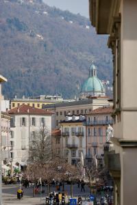 a view of a city with buildings and a mountain at Suite Cecilia by Piazza del Lago, Como Center in Como