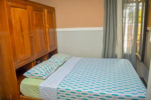 a bedroom with a bed and a wooden cabinet at Appart Naxel in Kinshasa