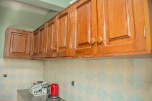 a kitchen with wooden cabinets on the wall at Appart Naxel in Kinshasa