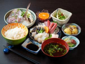 a table topped with bowls of food and other dishes at 柏島ヴィレッジ Kashiwajima Village in Otsuki
