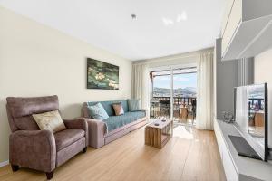 a living room with a couch and a tv at Seaview Oasis Luxury Duplex La Caleta in Adeje