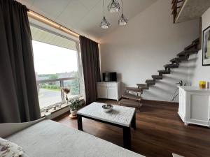 a living room with a staircase and a table at Antano sodyba in Dauparai