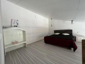 a bedroom with a black bed and white walls at Antano sodyba in Dauparai