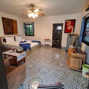 a bedroom with a bed and a living room at D&K Smiley Phuket Resort in Rawai Beach