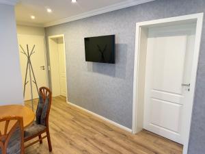 a living room with a table and a television on a wall at Apartment in Otterberg in Otterberg