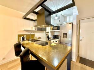 a kitchen with a large counter top in a kitchen at Dou Cocon, Calme et Confort Moderne in Sainte-Clotilde