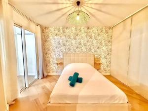 a bedroom with a bed with a green cross on it at Dou Cocon, Calme et Confort Moderne in Sainte-Clotilde