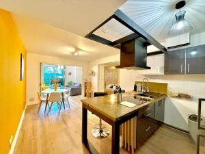 a kitchen with a island in the middle of a room at Dou Cocon, Calme et Confort Moderne in Sainte-Clotilde
