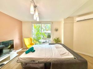 a bedroom with a large bed and a yellow chair at Dou Cocon, Calme et Confort Moderne in Sainte-Clotilde +6 photos