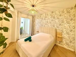 a bedroom with a white bed and a large window at Dou Cocon, Calme et Confort Moderne in Sainte-Clotilde