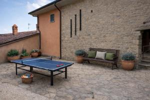 a ping pong table and a bench on a patio at Panoramic View Village of Villa Luigina Cortona in Castiglion Fiorentino