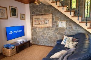 a living room with a leather couch and a stone wall at Panoramic View Village of Villa Luigina Cortona in Castiglion Fiorentino