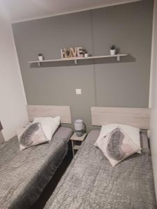 a bedroom with two beds and a shelf with the words love at U paradisu in Lumio