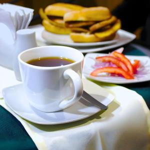 a cup of coffee on a table with plates of food at Lua Hostal - Arequipa in Arequipa