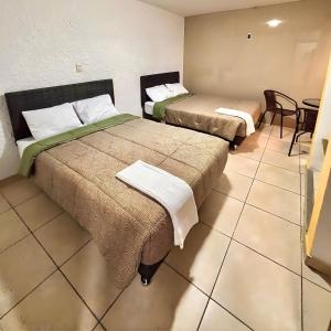 two beds in a room with a table and chairs at Lua Hostal - Arequipa in Arequipa