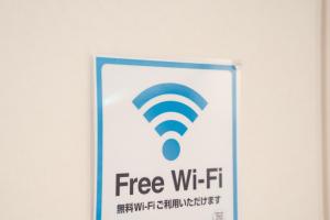 a sign with a free wifi sign on a wall at Shibuya City House 渋谷シティハウス in Tokyo