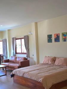 a bedroom with a large bed and a couch at Chortip House in Pai