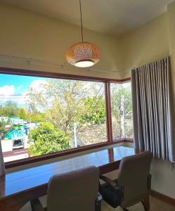 a dining room with a table and a large window at Chortip House in Pai
