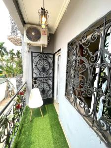a balcony with green grass and a fan at sidof Redence L&A in Yaoundé