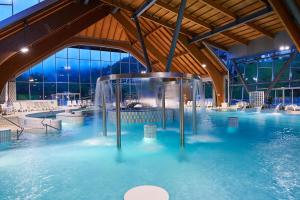 a pool of blue water in a building at NaturHotel Snovik in Kamnik