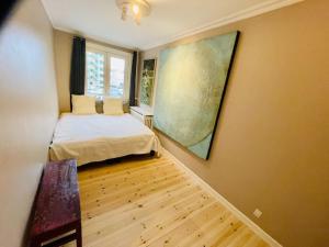a bedroom with a bed and a large painting on the wall at Deluxe Hotel Apartment in Charlottenlund