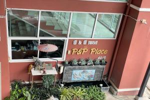 a pizza place with potted plants in front of a building at P&P Place in Kanchanaburi City