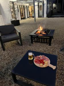 a table with a plate of food and a glass of beer at La Ferme de la Place in Bouvines