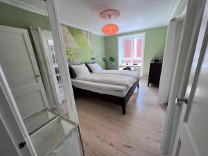 a living room with a bed and a window at Deluxe Hotel Apartment in Charlottenlund
