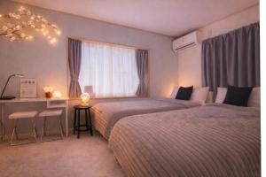 a hotel room with two beds and a desk and a window at Quiet Myoden-Disney & Tokyo Sightseeing Base in Ichikawa +58 photos