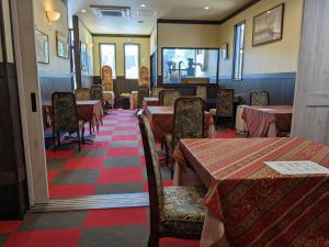 a dining room with tables and chairs in a restaurant at ル カフェ プランタニエ in Yokote