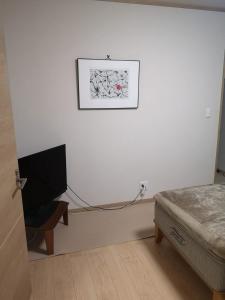 a bedroom with a bed and a tv on a wall at ル カフェ プランタニエ in Yokote