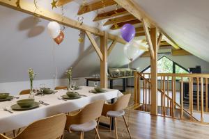 a dining room with a white table and chairs at Osada Hipodrom in Łąck