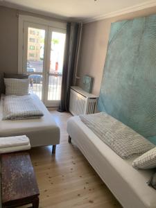 a bedroom with two beds and a window with a view at Deluxe Hotel Apartment in Charlottenlund +10 photos