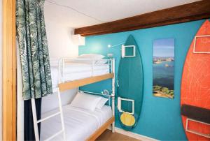 a bunk bed in a room with a surfboard on the wall at SURF HOSTEL BIARRITZ in Biarritz