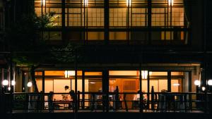 people standing outside of a building at night at Tazuru in Kyoto