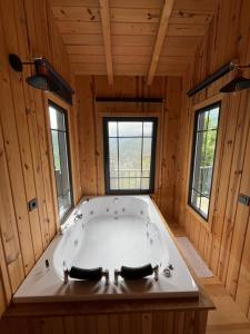 a large bath tub in a wooden room with windows at Varya Tatil Köyü in Çamlıhemşin