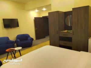 a room with a bed and two chairs and a tv at Larain Plaza Hotel in Aqaba