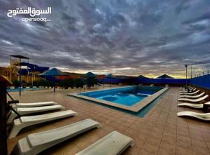 a swimming pool with lounge chairs next to at Larain Plaza Hotel in Aqaba