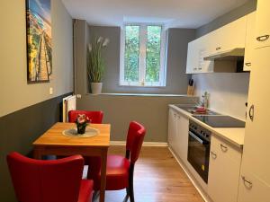 a small kitchen with a table and red chairs at Flensburg Zentrum 69 01 in Flensburg