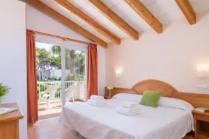 a bedroom with a bed and a large window at Villas Serena in Cala Blanca