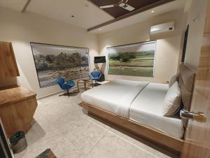 a bedroom with a bed and two paintings on the wall at Flamingo Club and Resort Una 3 Km Away from Diu Check Post in Diu