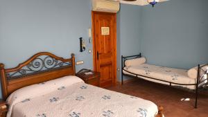 a bedroom with two beds and a door to a room at Casa Mola in Forcall