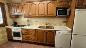 a kitchen with wooden cabinets and a sink and a refrigerator at Casa Mola in Forcall +7 photos
