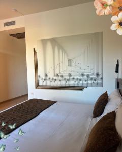 a bedroom with a large white bed with flowers on the wall at Au Moulin des Ecorces in Dole